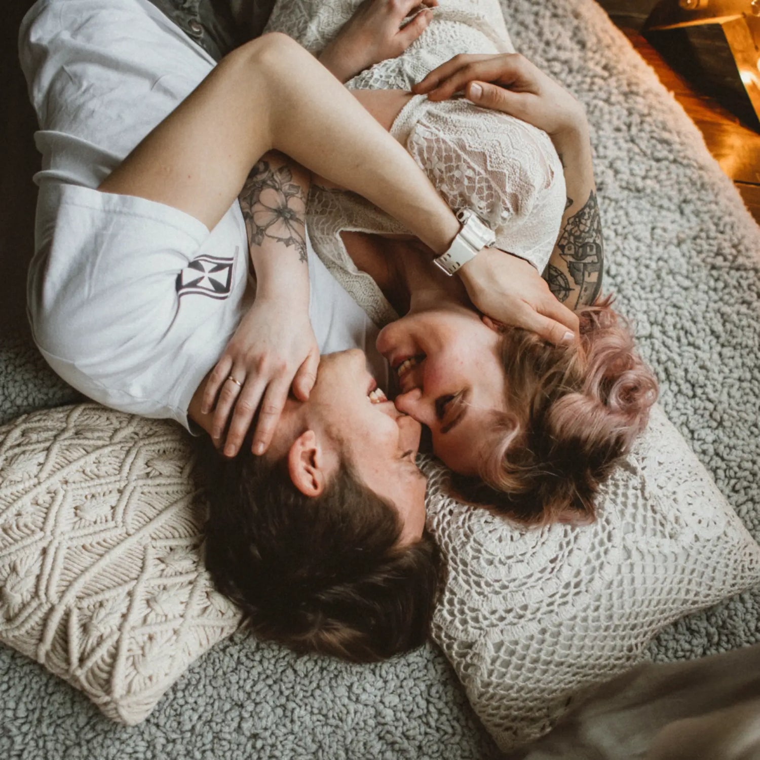 Couple lying on a Love Blanket, embracing each other.